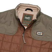 Two-tone quilted jacket detail showing zipper, chest patch logo, and interior brand label