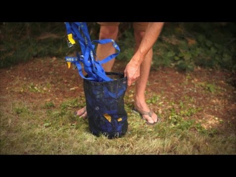 Blue cam straps with yellow buckles being packed into a mesh storage bag outdoors