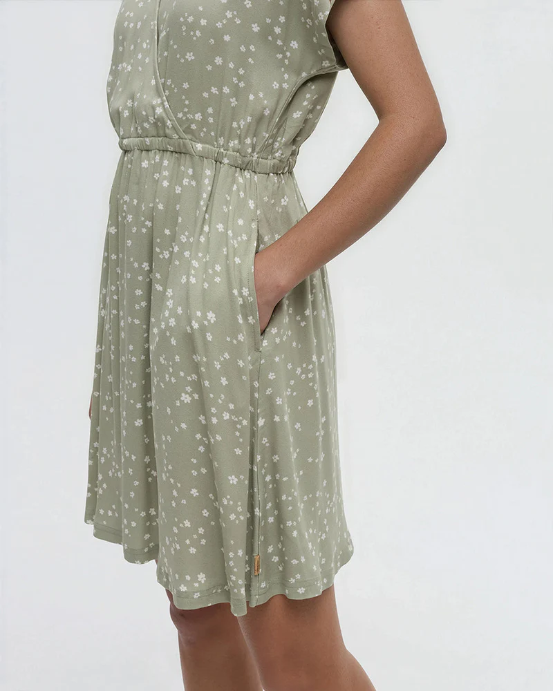 Light green sleeveless dress with small white floral pattern, drawstring waist, side pocket visible