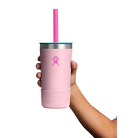 Hand holding a light pink insulated tumbler with teal lid, pink straw, and rubber boot base