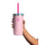 Hand holding a light pink insulated tumbler with teal lid, pink straw, and rubber boot base