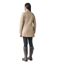 Women's quilted longline jacket in tan, back view, paired with tall boots and leggings