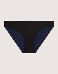 Reversible bikini bottom with black front panel and navy blue side panels, flat lay view