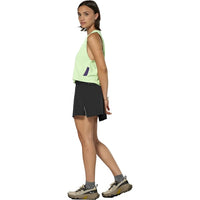 Women's athletic skort in dark black with side slit, paired with lime green tank top, side view