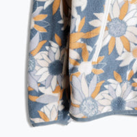 Light blue fleece sweatshirt with white and orange daisy floral pattern, partial side view