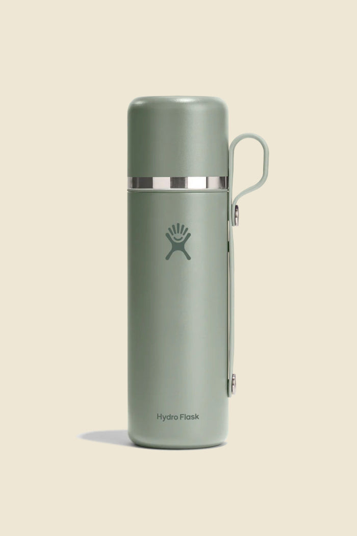Insulated stainless steel thermos with attached cup lid and carry loop, front view