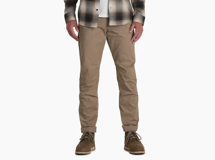 Men's slim-fit khaki chino pants with cuffed hem, worn with boots, front view