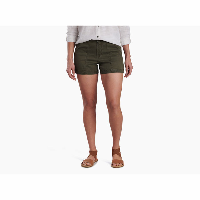 Woman wearing olive green cargo shorts with white linen shirt and brown sandals
