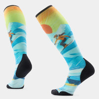 Knee-high ski socks with colorful skier graphic, blue background, and black heel and toe