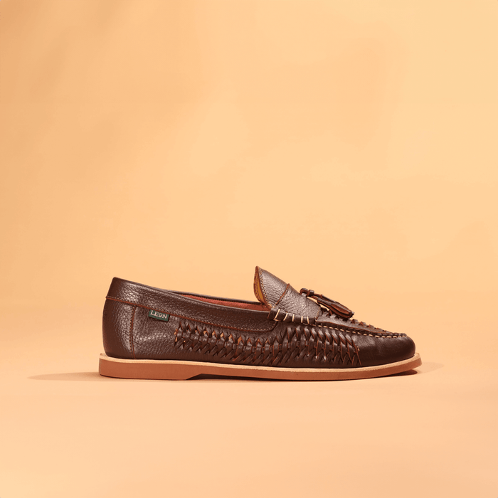 Men's woven leather tassel loafer in dark brown, lateral side view on neutral background