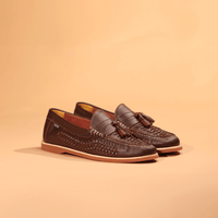 Men's woven leather tassel loafers in dark brown with tan sole, angled pair view