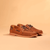 Brown leather boat shoes with woven texture and laces, side angle view