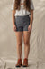 Dark gray high-waisted trail shorts with front pockets, worn with hiking boots