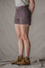 Dark purple trail shorts with button closure and side pockets, worn with hiking boots