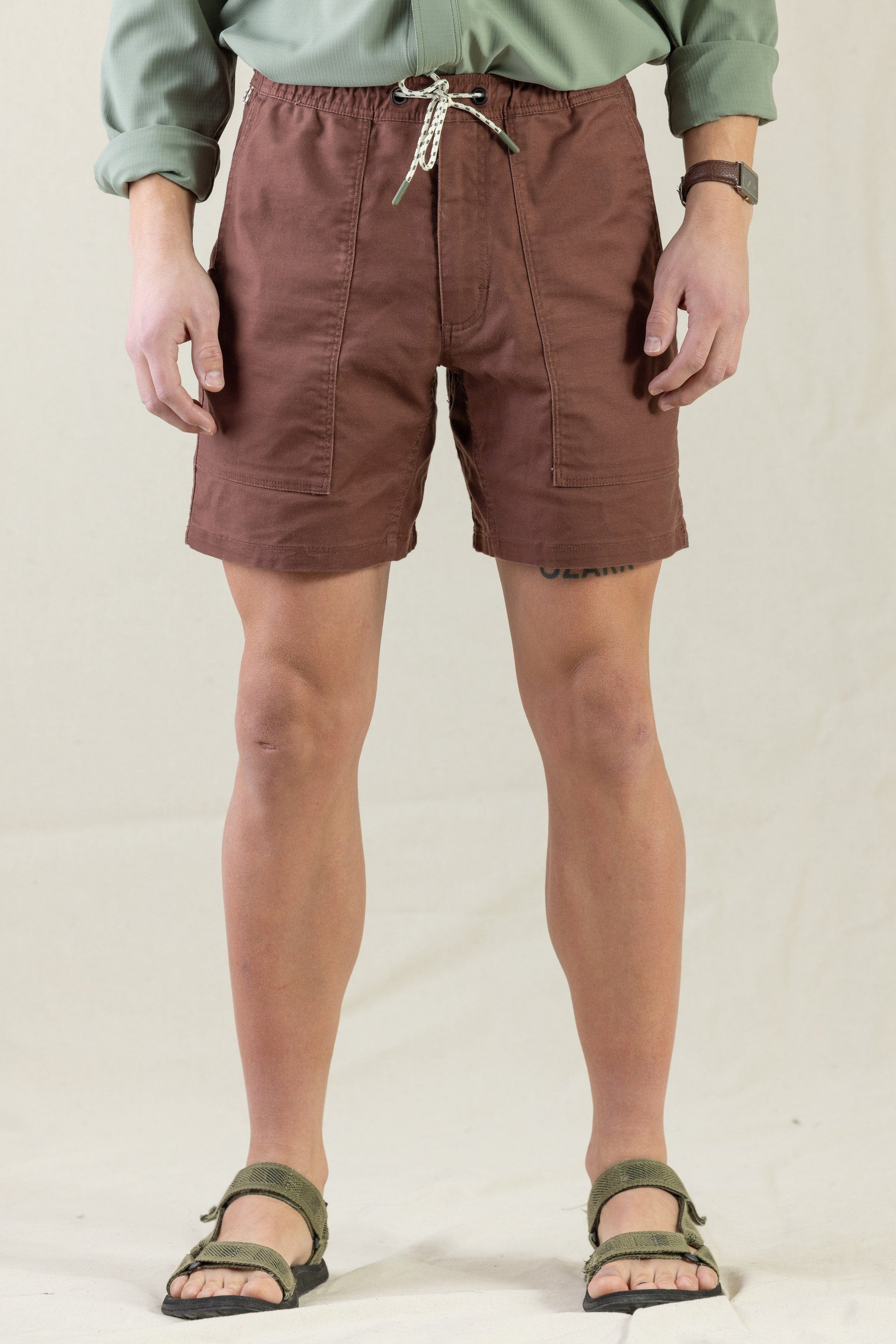 Brown drawstring shorts with elastic waistband and front pockets, modeled on person