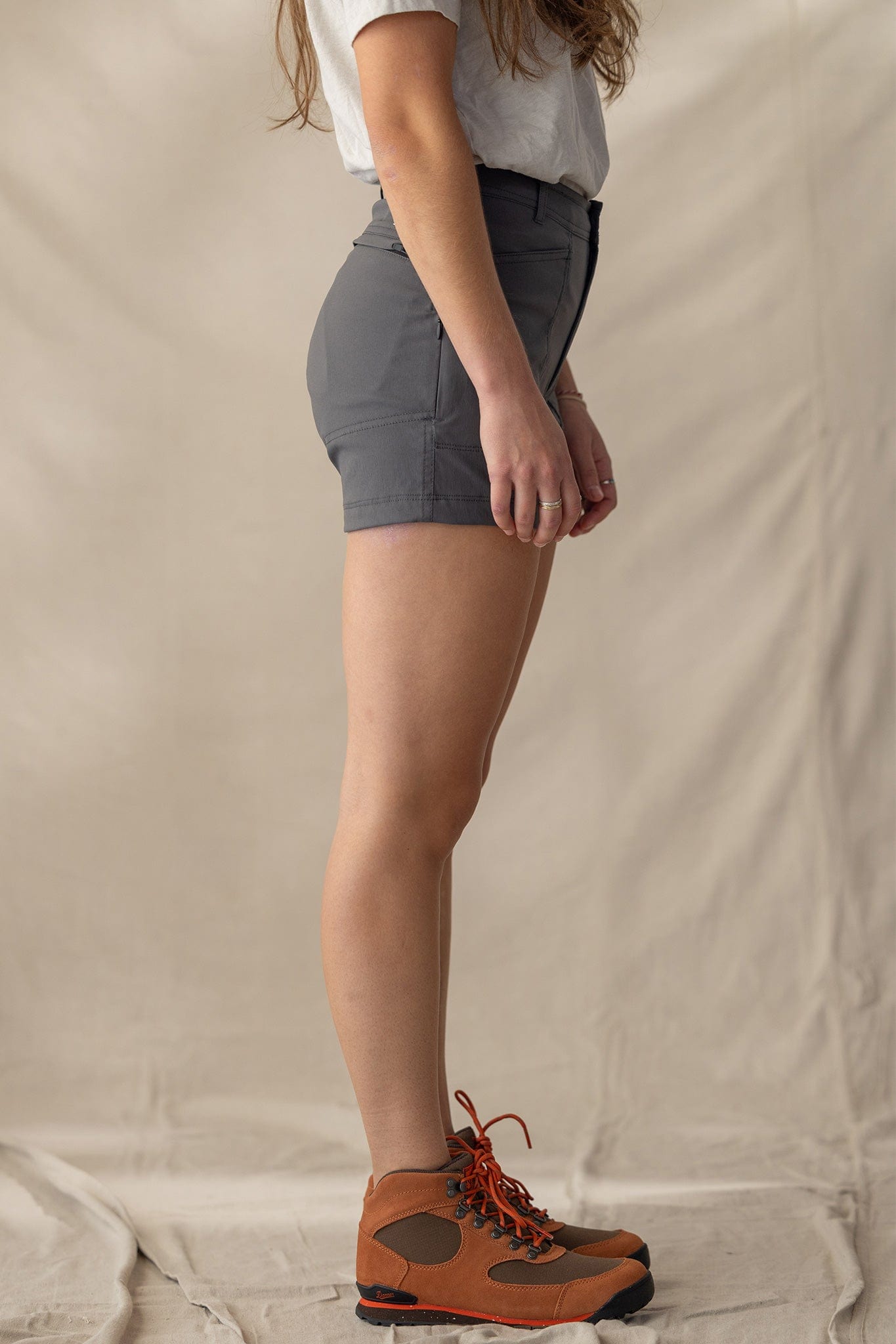 Charcoal gray trail shorts worn with hiking boots, side profile view showing fit and length