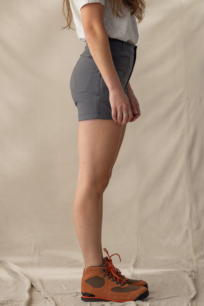 Charcoal gray trail shorts worn with hiking boots, side profile view showing fit and length