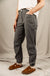 Women's dark gray trail pants with large side pockets, worn with suede clogs, side view