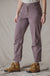 Women's trail pants in dusty mauve with front pockets and snap cuffs, paired with hiking boots