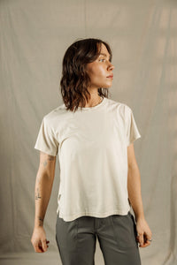 Woman wearing cream colored relaxed fit t-shirt with olive green pants, side profile view