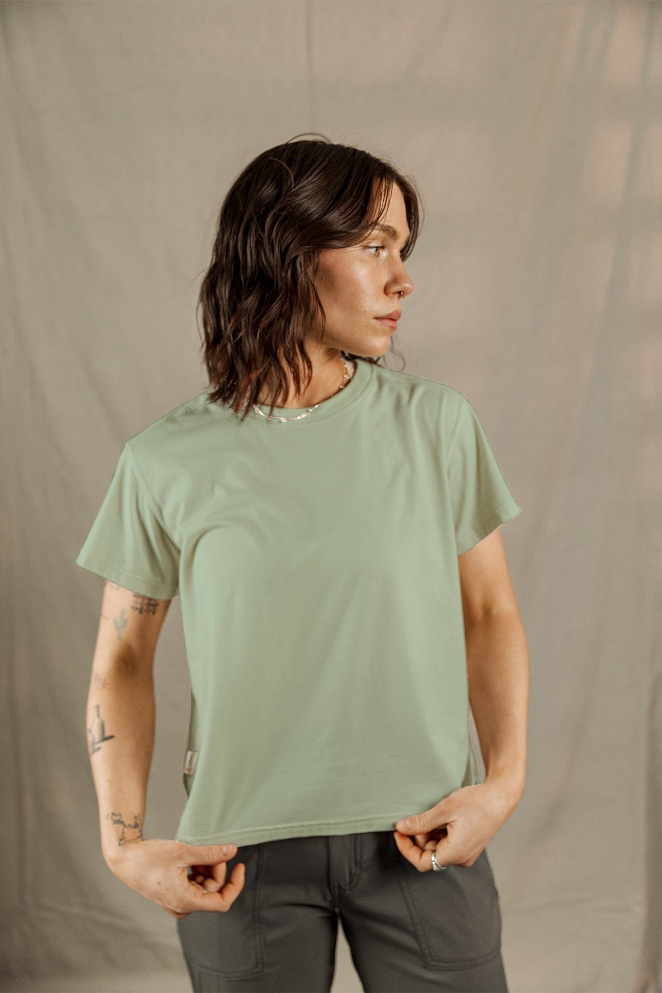 Woman wearing sage green short-sleeve t-shirt with relaxed fit, three-quarter view