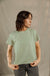 Woman wearing sage green short-sleeve t-shirt with relaxed fit, three-quarter view