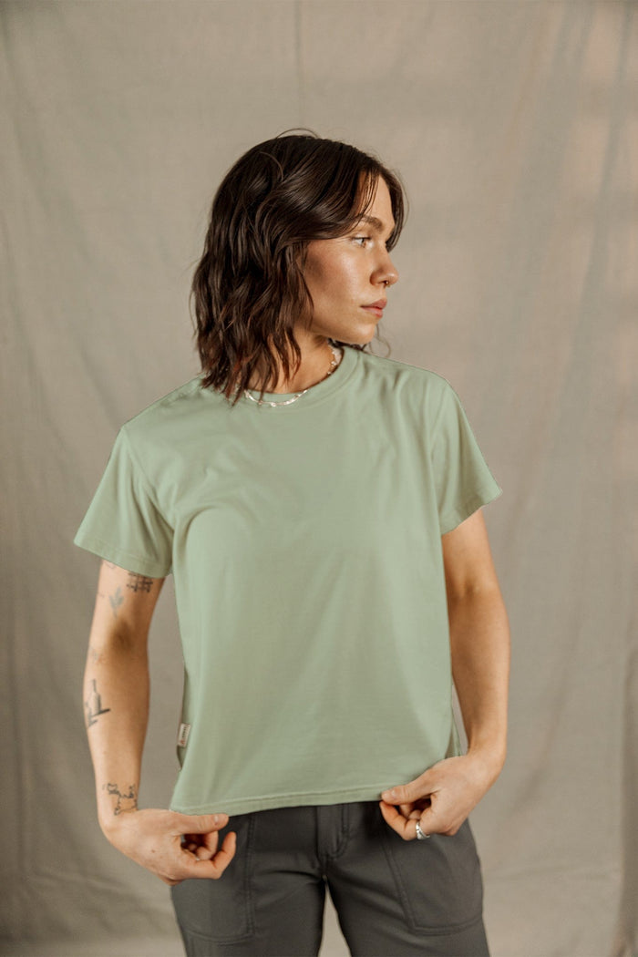 Woman wearing sage green short-sleeve t-shirt with relaxed fit, three-quarter view