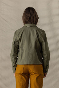 Women's olive green utility jacket, back view, with mesh ventilation panel and snap cuffs