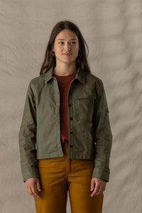 Women's olive green button-up shirt jacket with chest pockets, worn open over red top