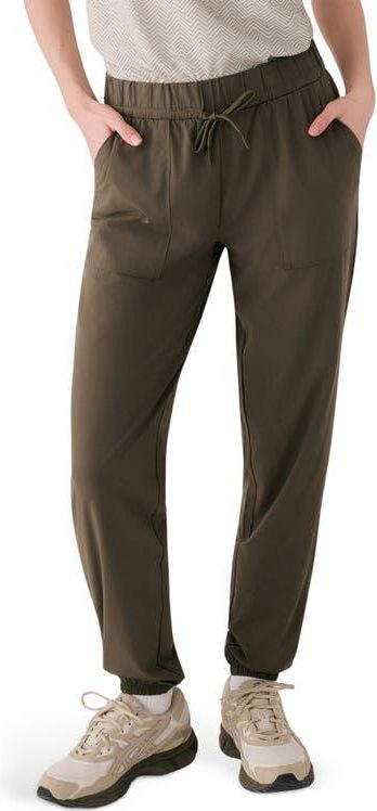Olive green jogger pants with elastic waistband and drawstring, worn with sneakers
