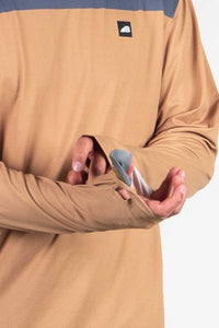 Person wearing tan hoodie with blue accents holding sunglasses cleaning cloth