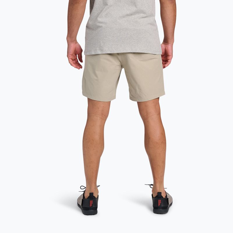 Light beige athletic shorts shown from behind on model with gray shirt