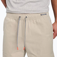 Light beige shorts with elastic waistband and drawstring ties with coral-colored tips