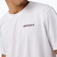 White men's short sleeve graphic tee with small logo on chest, close-up front view