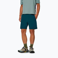 Dark teal athletic shorts worn with hiking boots and green socks, rear three-quarter view