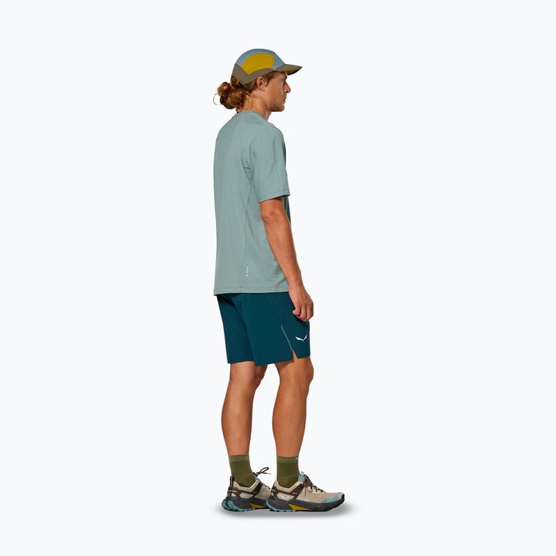 Teal athletic shorts worn by man in profile view with hiking boots