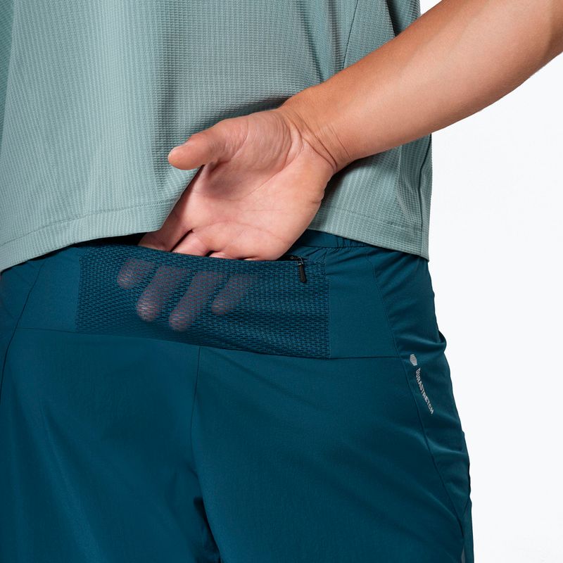 Teal athletic shorts with mesh back pocket detail, worn by person from waist down