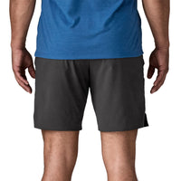 Black athletic shorts worn by man, front view showing mid-thigh length and relaxed fit