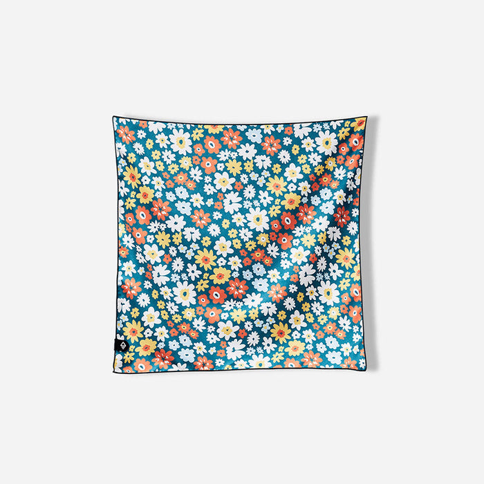 Square bandana towel with colorful floral pattern featuring small flowers on teal background