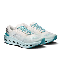 Women's running shoes with white mesh upper, chunky light blue midsole, and teal laces, three-quarter view