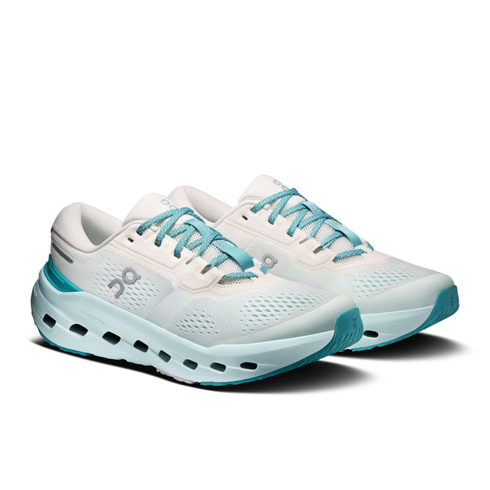 Women's running shoes with white mesh upper, chunky light blue midsole, and teal laces, three-quarter view