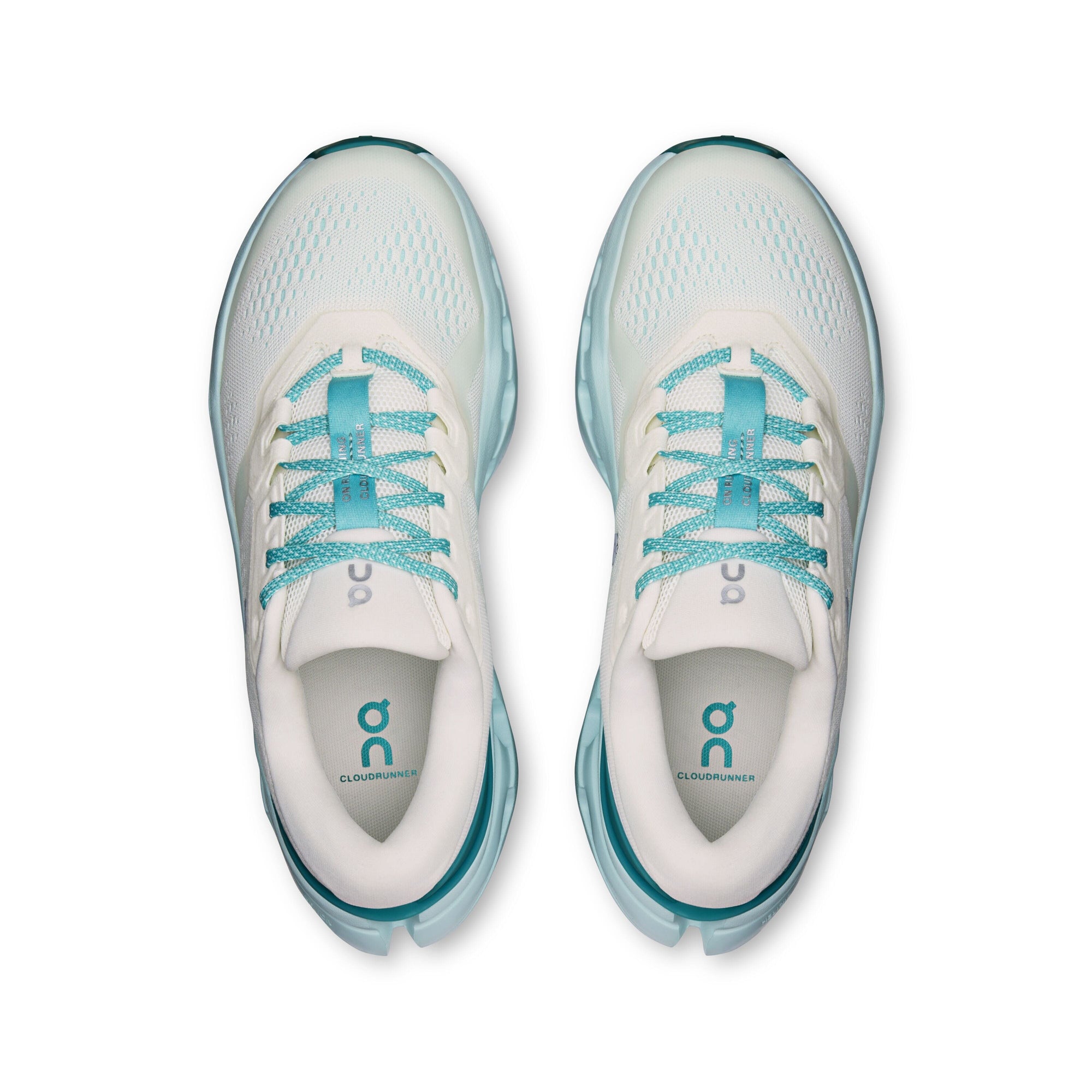 Top-down view of a pair of women's running shoes with cream upper and teal laces