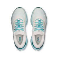 Top-down view of a pair of women's running shoes with cream upper and teal laces