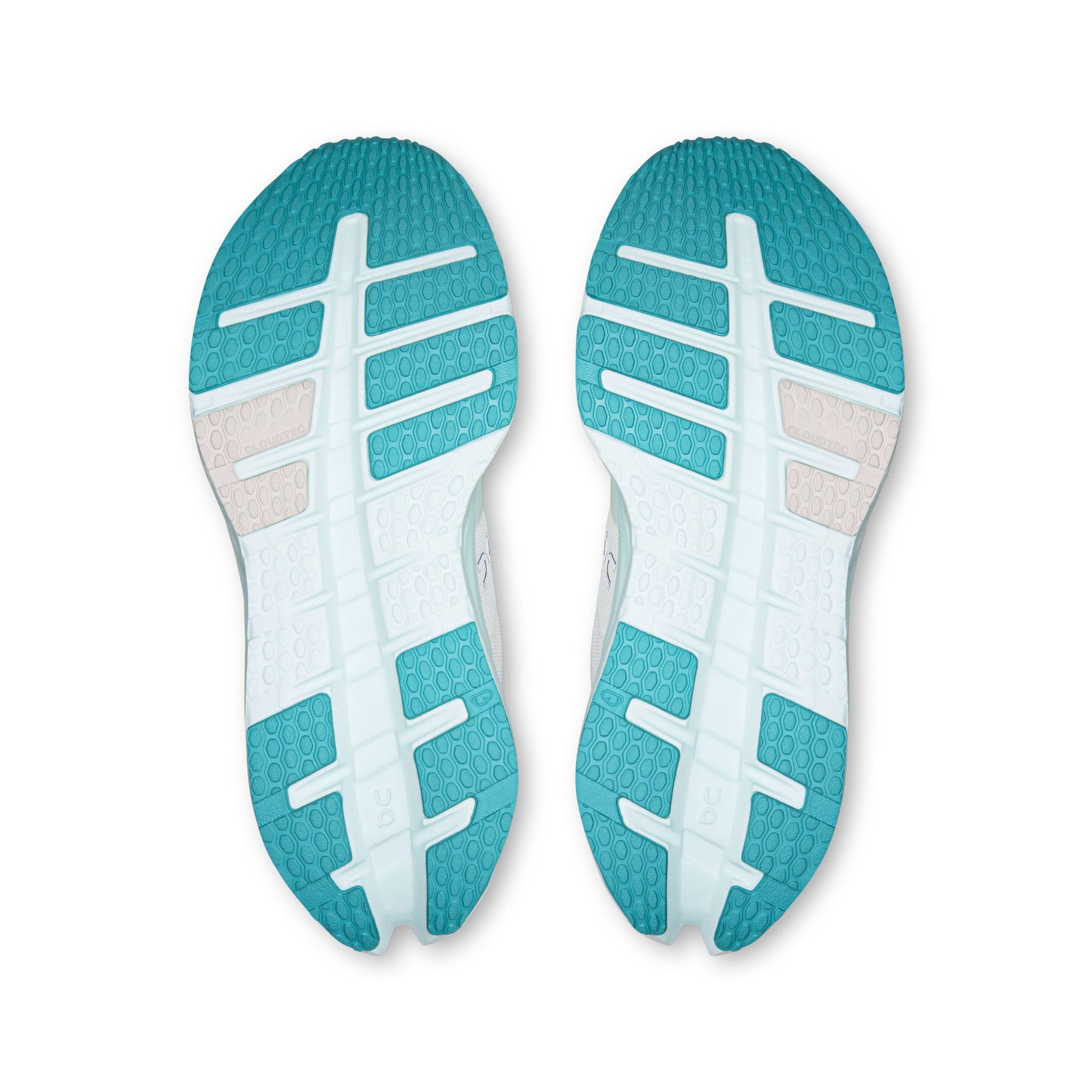 Bottom view of a pair of women's running shoes with teal and white outsole pattern
