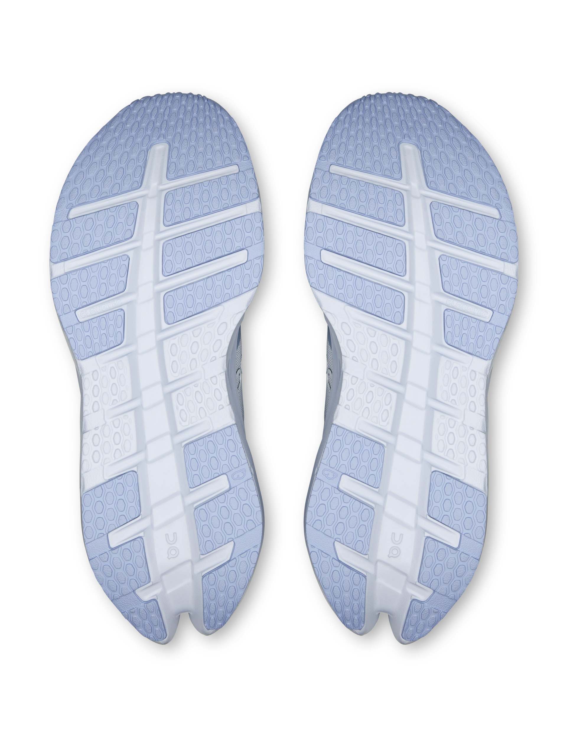 Bottom view of a pair of women's running shoes showing light blue outsole with hexagonal tread pattern