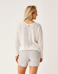 Women wearing cream mesh knit pullover sweater with denim shorts, back view showing texture
