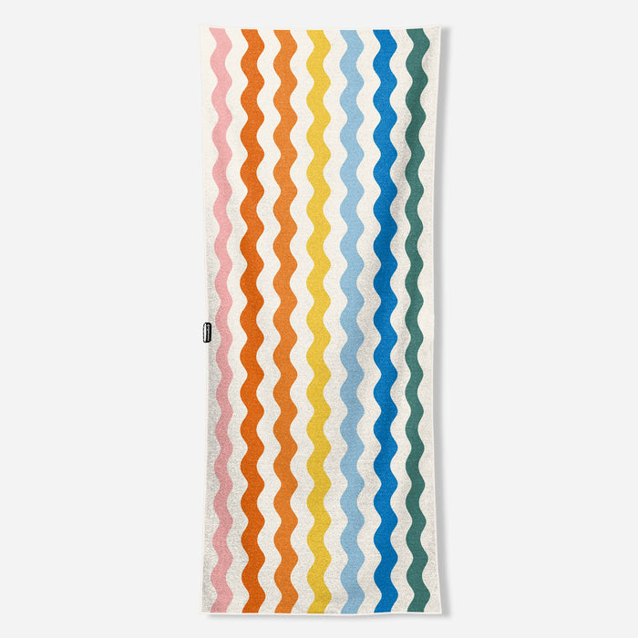 Rectangular towel with colorful wavy vertical stripes in rainbow pattern on white background