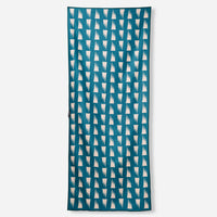 Rectangular towel with teal background and repeating white geometric tooth pattern