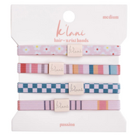 Set of four patterned hair ties and wristbands in pink and multicolor designs on branded card