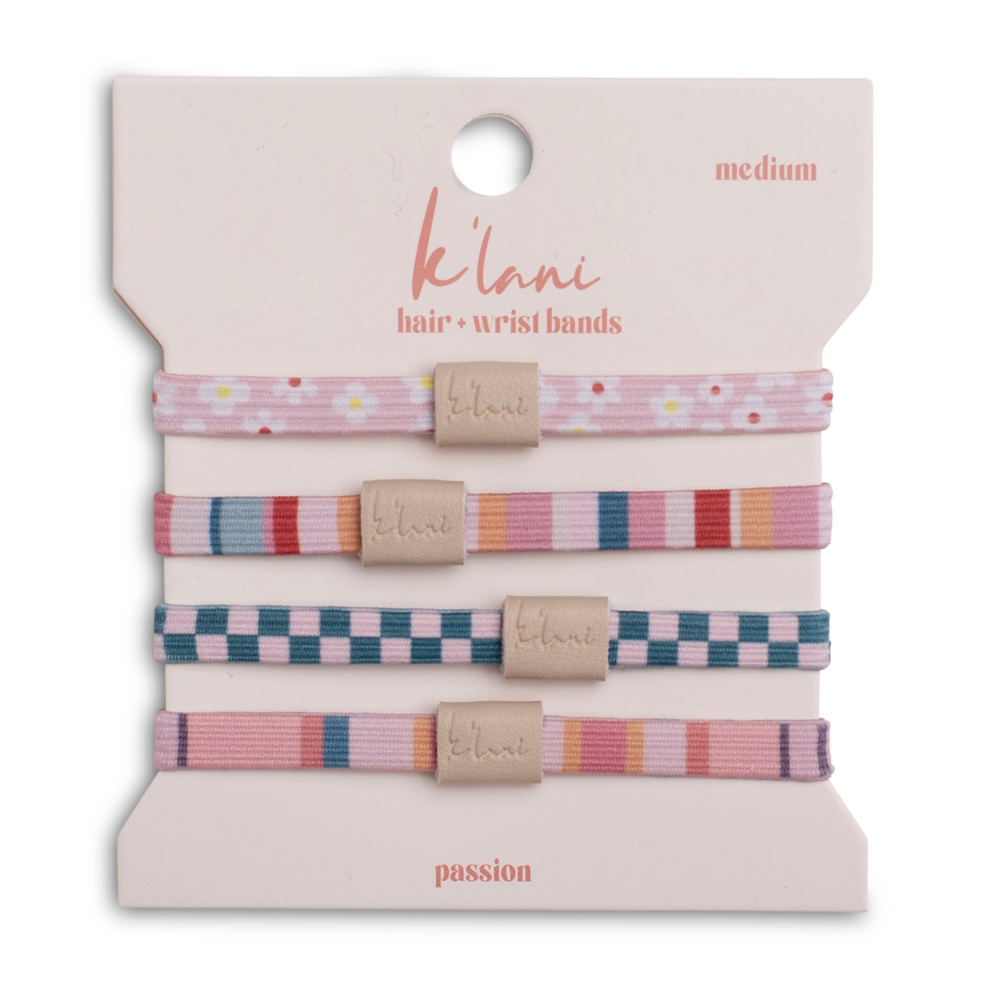 Set of four patterned hair ties with logo tags on retail packaging card, medium size